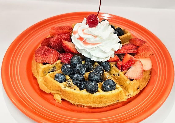 Belgian waffle with strawberries, blueberries, and whipped cream